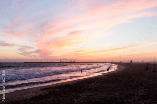 Sunset over waves hitting the beach on the west coast