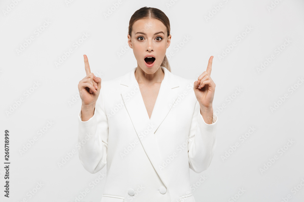 Photo of successful businesswoman pointing fingers upward at copyspace with surprise Photo of successful businesswoman pointing fingers upward at copyspace with surprise