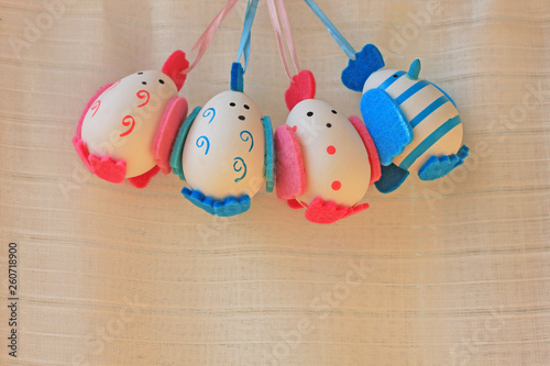 Easter holiday concept with cute handmade eggs, chicks with felt wings, tail and tuft