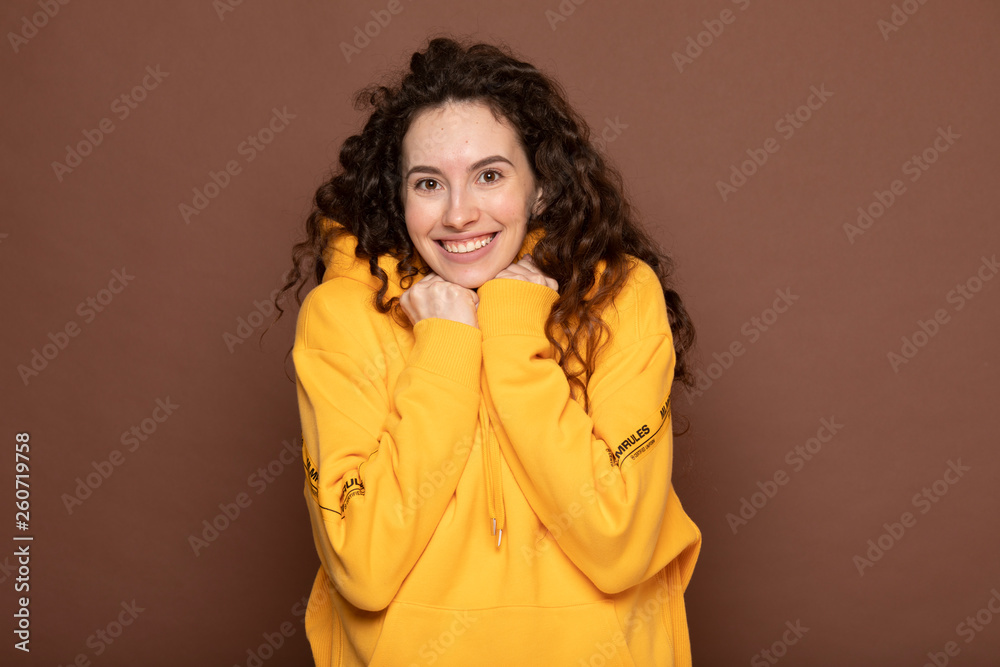 Happy brunette woman rejoicing her success and victory clenching her fists with joy. Lucky woman with curly hair being happy to achieve her aim and goals. Positive emotions, feelings Happy brunette woman rejoicing her success and victory clenching her fists with joy. Lucky woman with curly hair being happy to achieve her aim and goals. Positive emotions, feelings