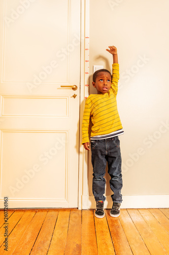 Valokuva boy measuring his height benchmark on door at home