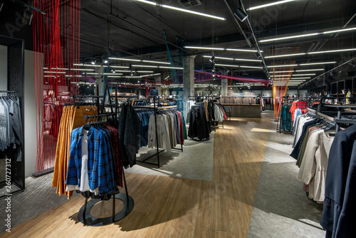 Modern clothes shop with large selection of different wear and shoes