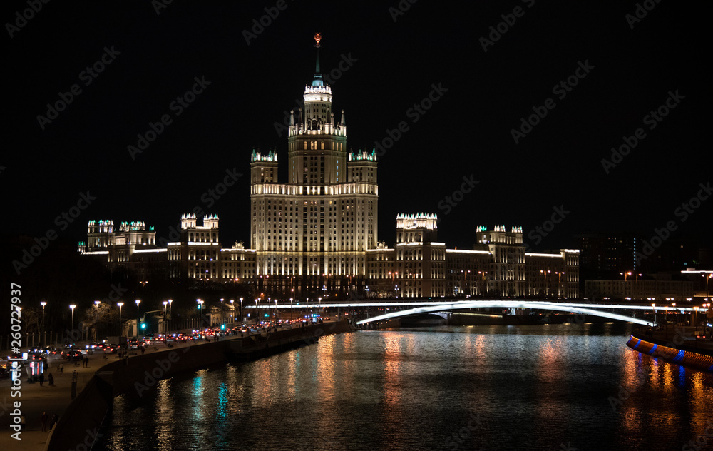 Evening landscape.View from the bridge to the waterfront. Moscow river.Dark sky.Beautifully illuminated buildings.