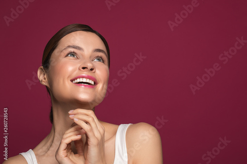 Delighted woman smiling and looking up while standing alone
