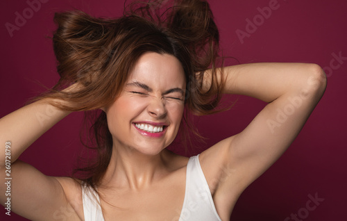 Expressive woman smiling and messing her hair up