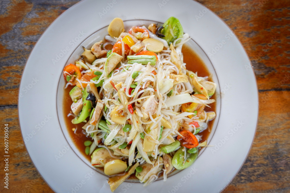 Green papaya salad spicy with rice noodle mix vegetable and fruit on white plate / Som tam thai food Green papaya salad spicy with rice noodle mix vegetable and fruit on white plate / Som tam thai food