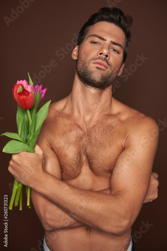 Obraz na plátně Topless muscular macho man with tulips bunch