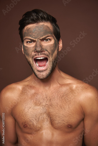Screaming excited muscular guy with face mask