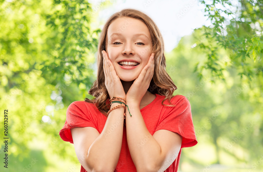 emotion, expression and people concept - happy smiling teenage girl with long hair in red t-shirt over green natural background emotion, expression and people concept - happy smiling teenage girl with long hair in red t-shirt over green natural background