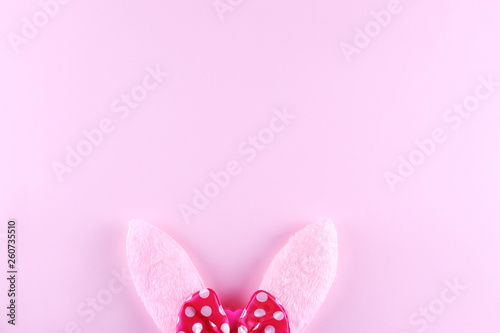 Fluffy Easter bunny ears as symbol of Christian religious holiday. Copy space, close up, flat lay, top view, bright colorful background.