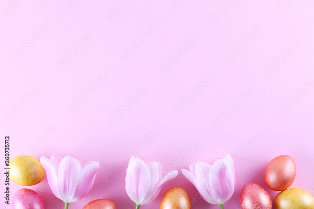 Bunch of hand painted Easter eggs of different pastel glossy color on bright paper background with a lot of copy space for text. Top view, flat lay, close up. Easter greeting card concept.