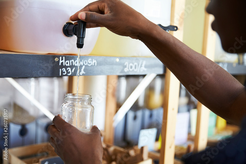 Man Filling Container From Dispenser For Body And Beauty Products In Plastic Free Grocery Store