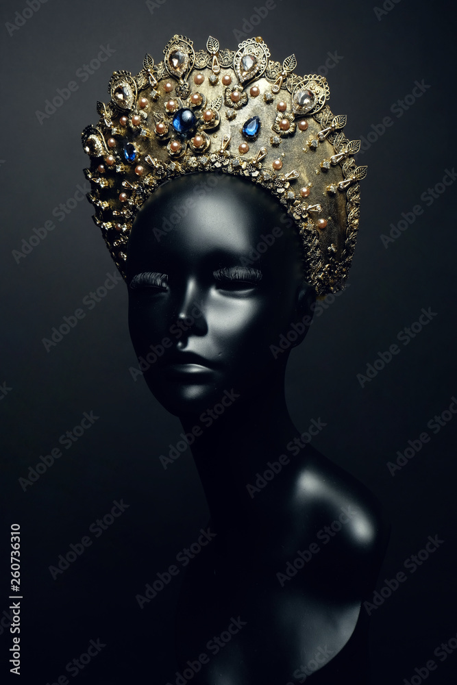 Head of mannequin in decorated bronze kokoshnick, dark studio background Head of mannequin in decorated bronze kokoshnick, dark studio background