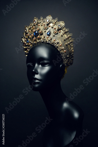Head of mannequin in decorated bronze kokoshnick, dark studio background