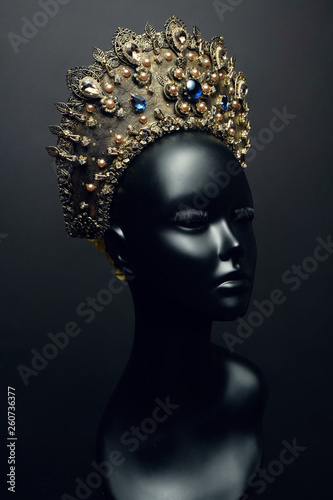 Head of mannequin in decorated bronze kokoshnick  dark studio background
