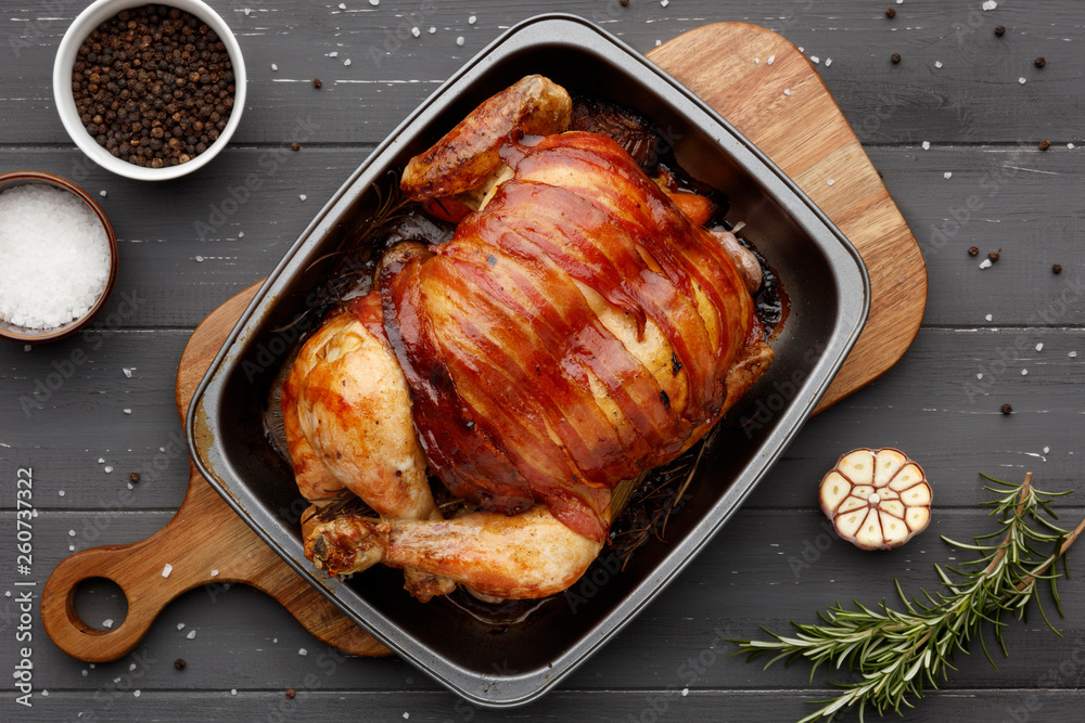 Fototapeta premium roast chicken in a rasting tin with ingredients on dark grey