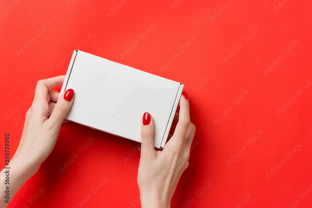 Female hands with white box on red background
