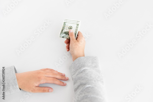 business, finance and corruption concept - close up of woman hand holding us dollar money on white background