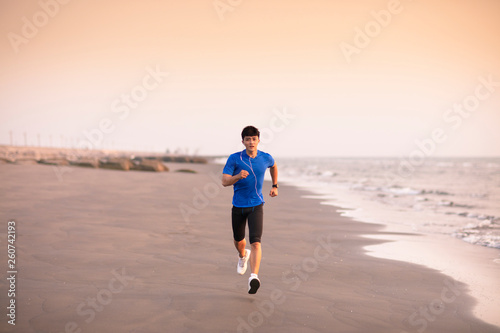 young Man running on  beach at sunset © Tom Wang