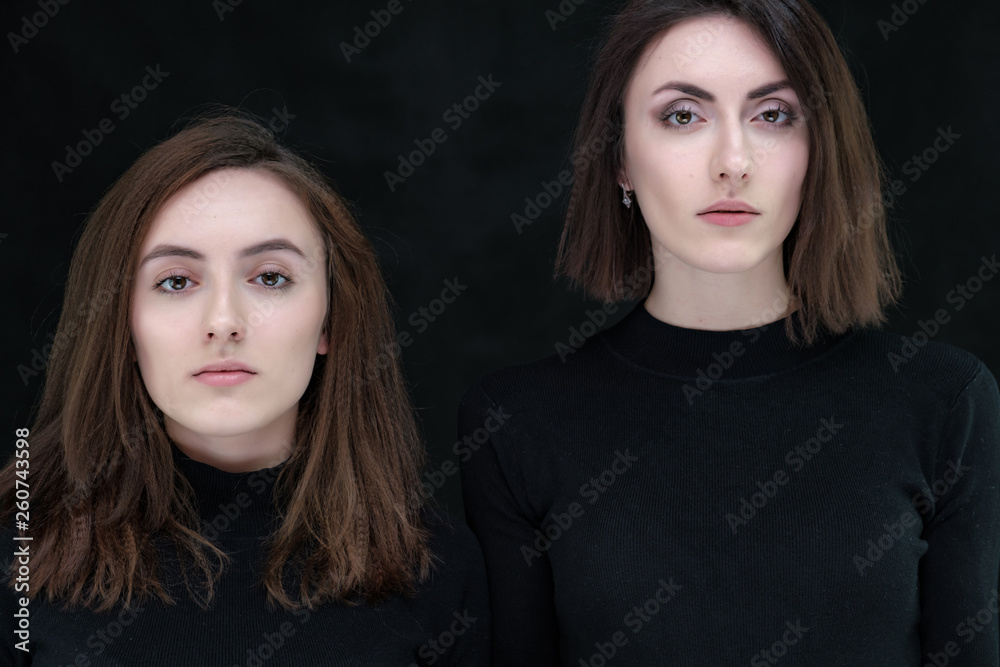 Concept portrait of two stylish brunette sisters on a black background in various poses. Fashionable photo of two beautiful girls with dark hair Concept portrait of two stylish brunette sisters on a black background in various poses. Fashionable photo of two beautiful girls with dark hair