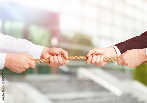 Business people pulling rope in opposite directions at office © BillionPhotos.com