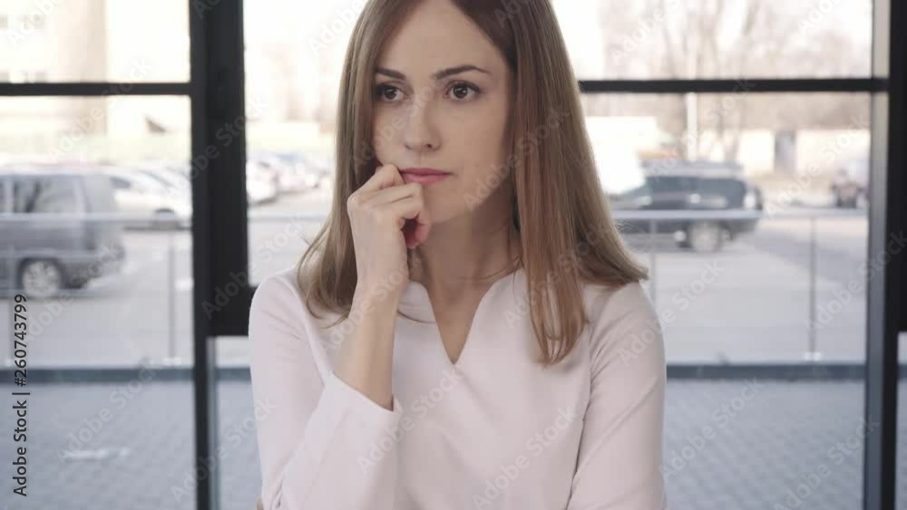worried woman standing, rubbing hands and touching face before job interview worried woman standing, rubbing hands and touching face before job interview