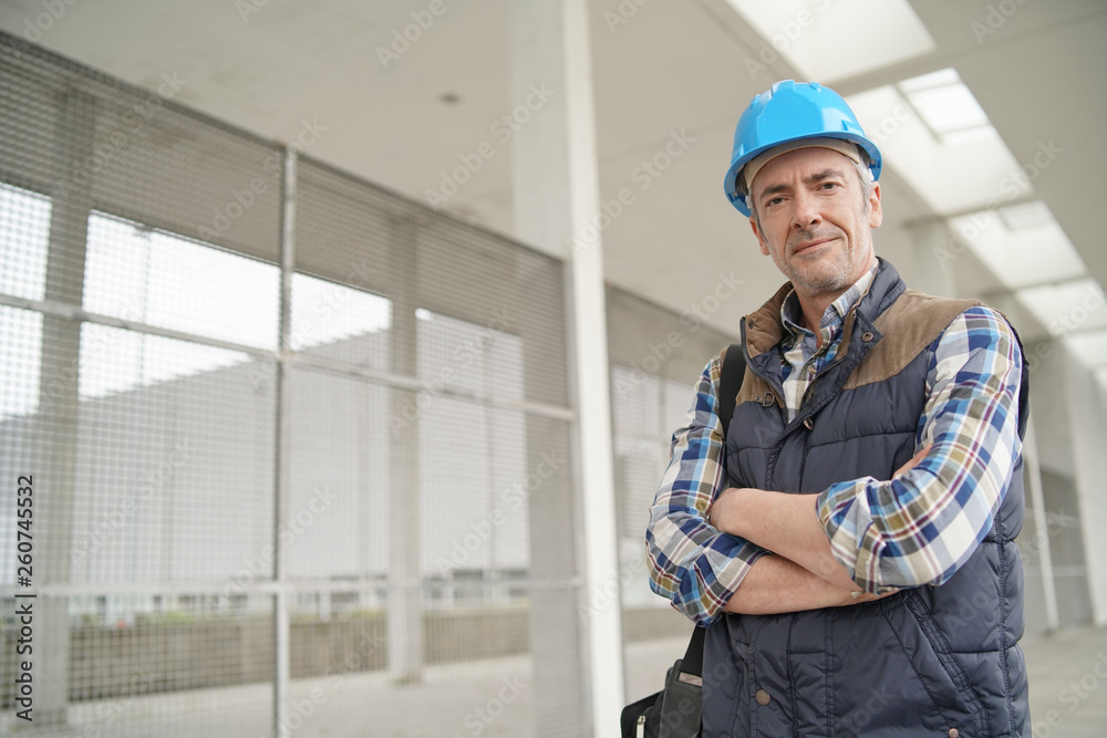 Construction worker looking at camera outside contemporary building