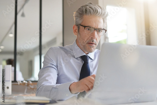 Businessman wearing glasses working in contemporary office