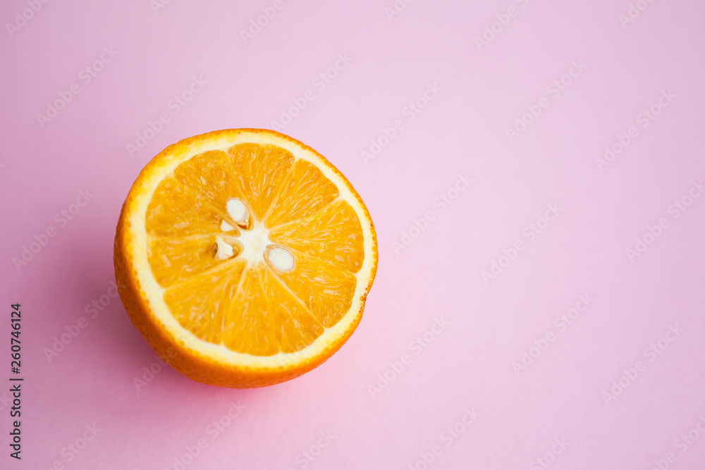 Half of orange on the pink background Half of orange on the pink background