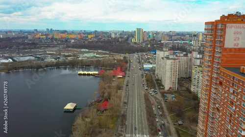 Small aerial frontwards dolly, Kharkivskiy area with pond on the left side and street below. photo