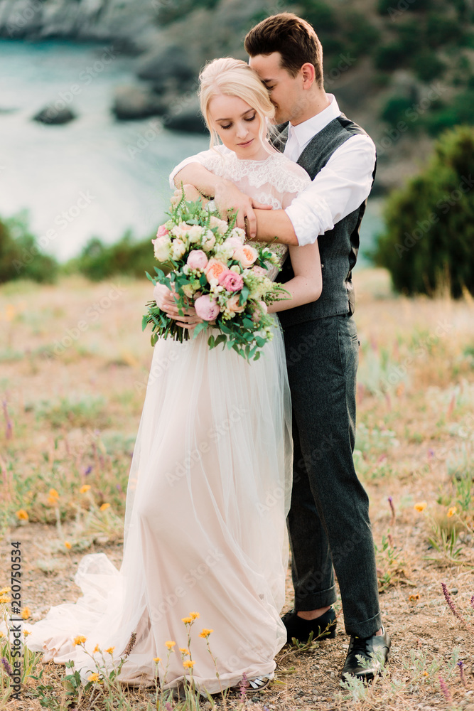 Beautiful portrait of bride and groom hug each other tender