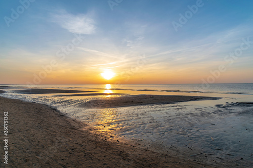 Fototapeta Naklejka Na Ścianę i Meble -  orabge colored sunset over calm sea beach water fields