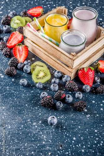 Summer fruits and berries smoothie drink. Vitamin diet snack beverage, with blueberries, strawberries, blackberries, kiwi. Dark blue concrete background copy space