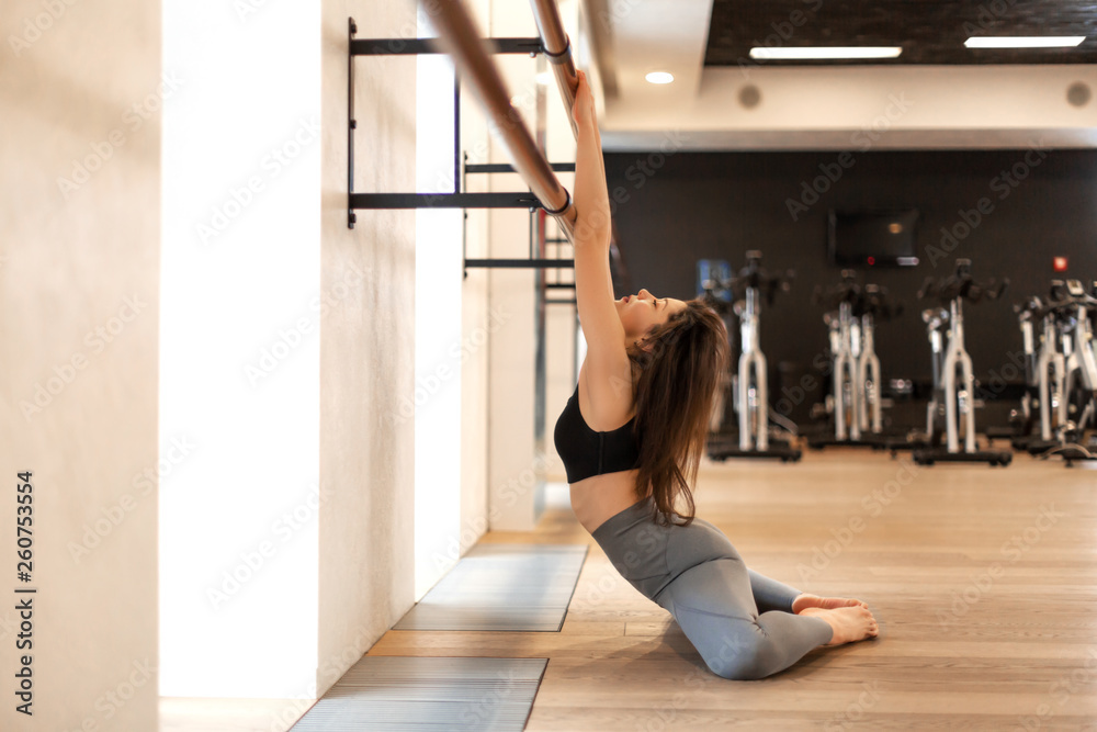 Young sexy woman doing stretching exercises in gym Young sexy woman doing stretching exercises in gym