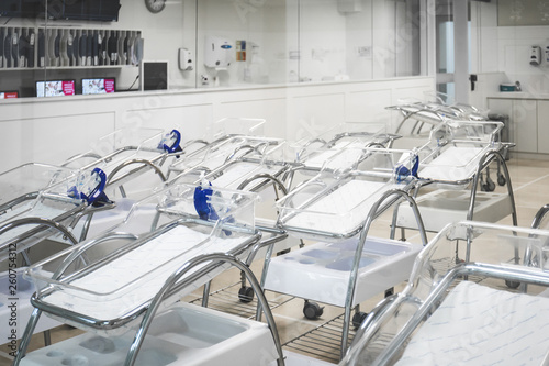 Maternity room in hospital and empty cribs of children lined up