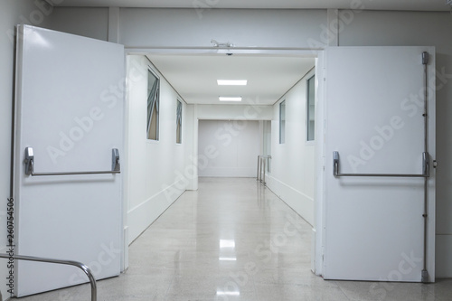 White hospital corridor. Clinic or maternity with white doors stretchers and boards.