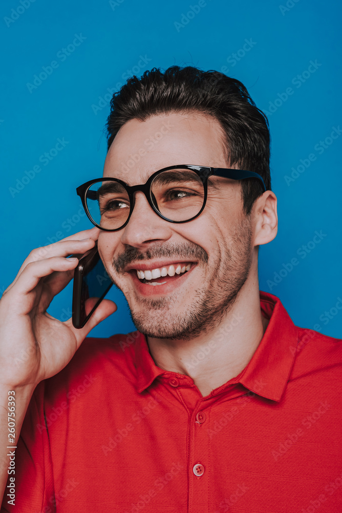 Low angle portrait of happy man talking on smartphone in studio Low angle portrait of happy man talking on smartphone in studio