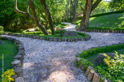 El camino del jardín está lleno de pétalos de flor.