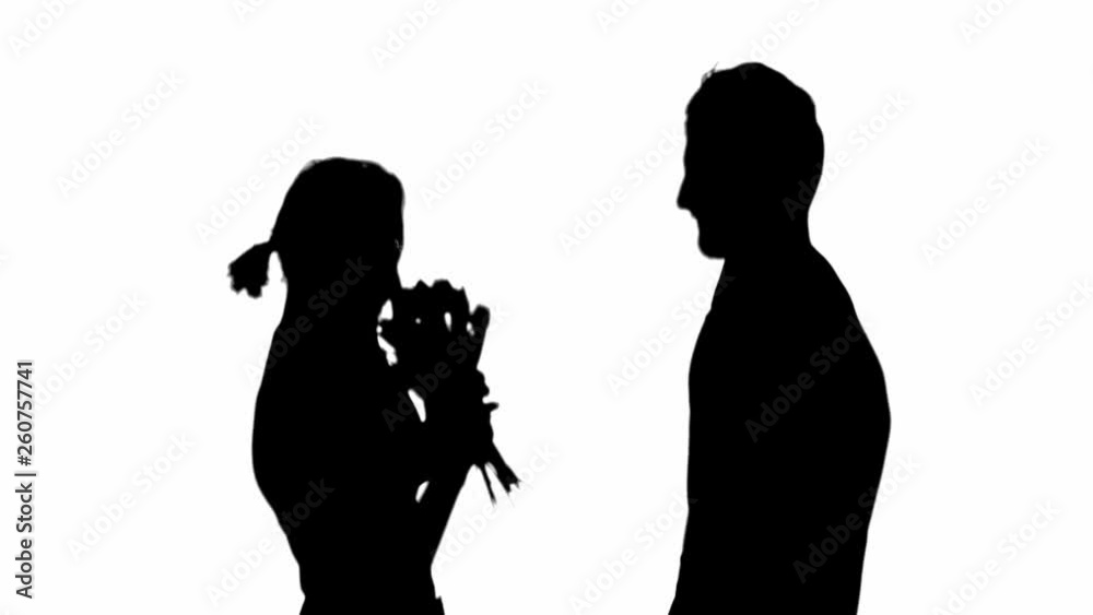 Side view of silhouette of man presenting flower bouquet to woman and embracing isolated on white Side view of silhouette of man presenting flower bouquet to woman and embracing isolated on white
