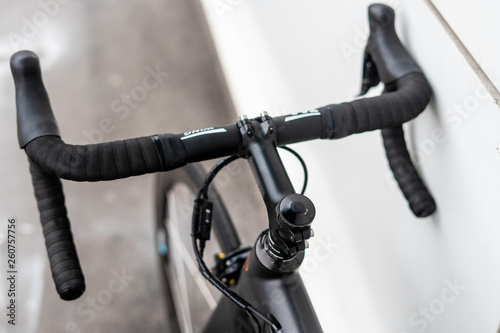 Black road bike handlebar with brake levers and cables