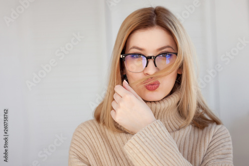 Charming young girl in a glasses. Young woman Makes air a kiss