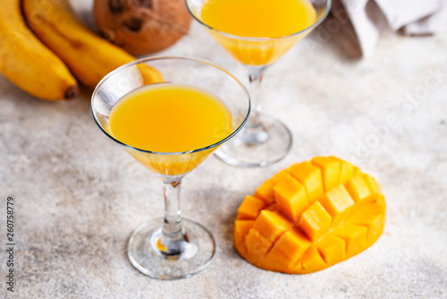 Tropical cocktail with mango on light background