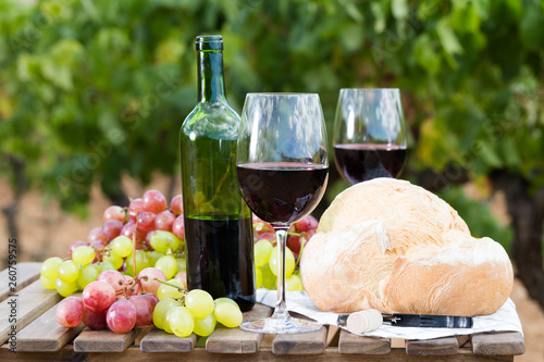Fototapeta Naklejka Na Ścianę i Meble -  still life with glass of red wine grapes and bread on table