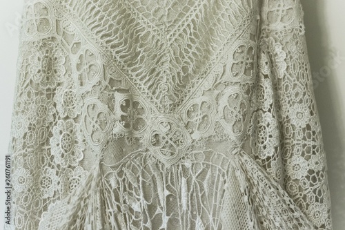 Detail of a white wedding dress hanging.