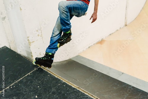 Inline skater, skating on a ramp in a skatepark.