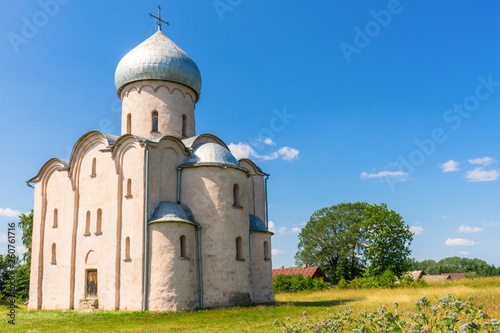 Church of Our Saviour on Nereditsa, Velikiy Novgorod vicinity, Russia. Russian countryside landscape with ancient orthodox temple against blue sky. Architectural landmark, UNESCO world heritage site photo