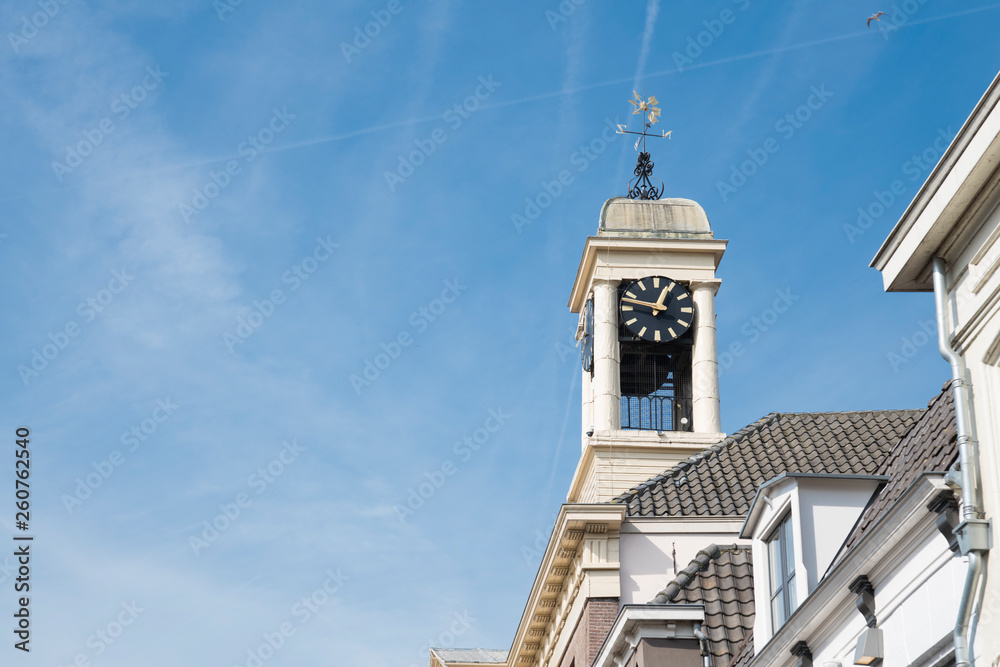 white tower of city hall with clock  in fortified city Harderwijk, Netherlands, against blue sky. Space for text