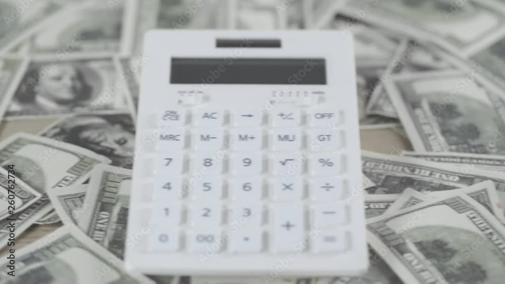 selective focus of scattered dollar banknotes and calculator on wooden desk selective focus of scattered dollar banknotes and calculator on wooden desk