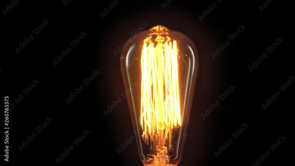 incandescent light bulb flickering isolated on black with copy space
