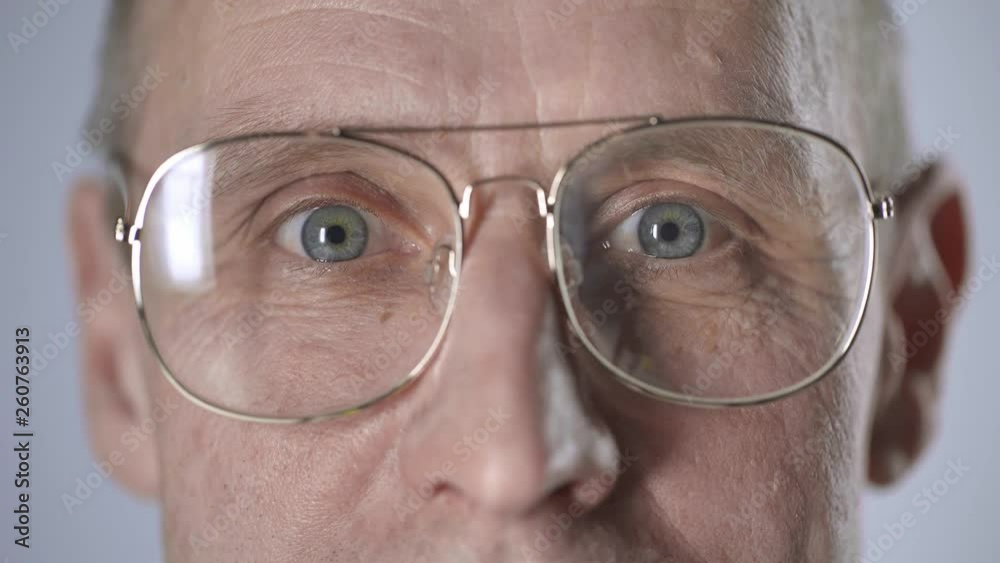 cropped view of middle aged man in glasses looking at camera and blinking isolated on grey cropped view of middle aged man in glasses looking at camera and blinking isolated on grey